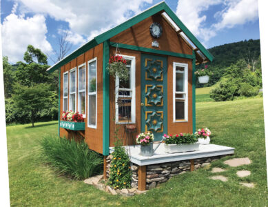 brown garden shed with green trim and green door with gold detai